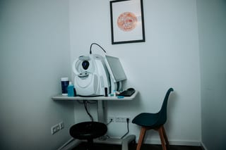 OCT-Gerät zur Netzhautuntersuchung im Diagnostikraum, daneben ein Bild einer Netzhautaufnahme